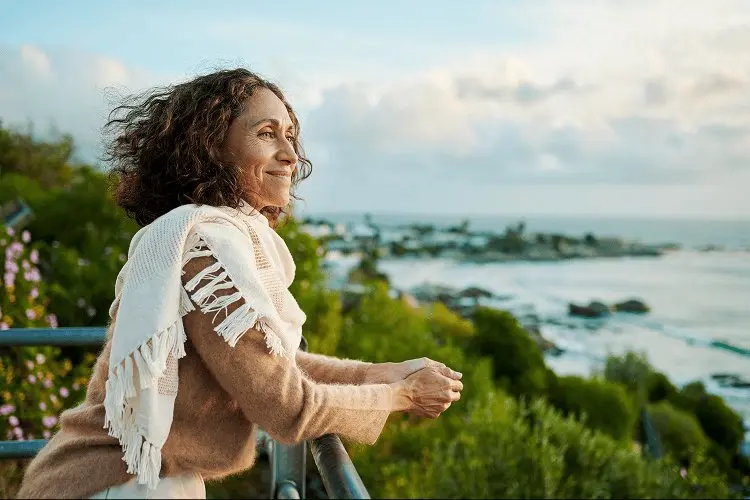 Smiling woman looking out at the sunset over the ocean