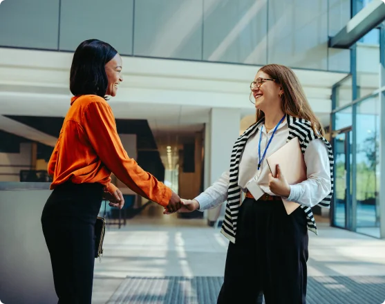 Two Soliant employees smiling and talking together in the office.