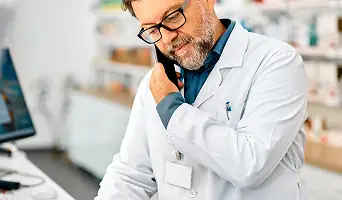 A smiling healthcare professional holding a clipboard