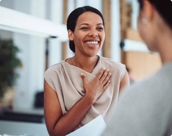 A smiling healthcare professional speaking with a colleague.