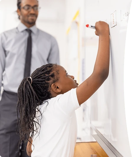 A teacher working with a student at a whiteboard