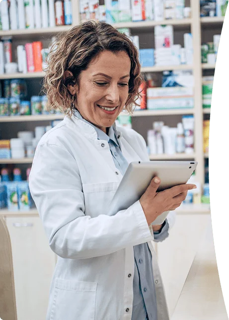 Pharmacist smiling while reviewing information on a tablet