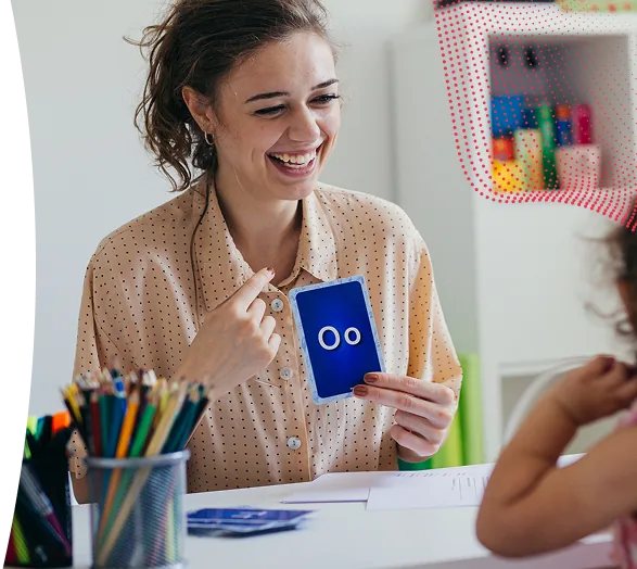 A smiling educator holding a card.